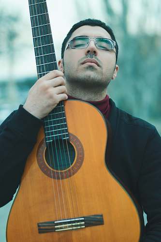 mandolin man holding brown acoustic guitar musician
